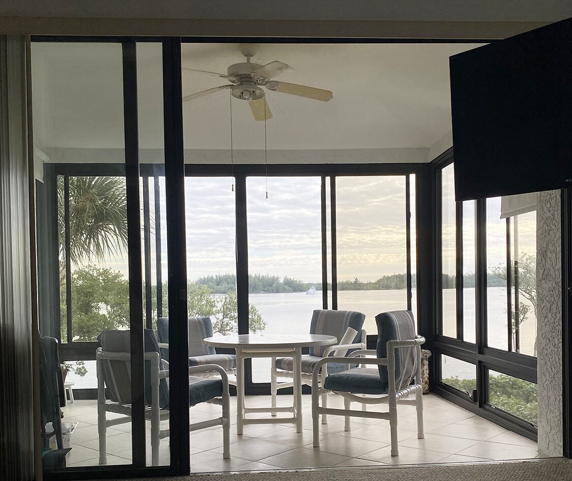 Screened porch with water view and dining table